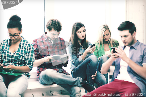 Image of students looking into devices at school