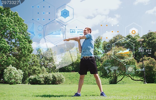 Image of smiling man stretching outdoors