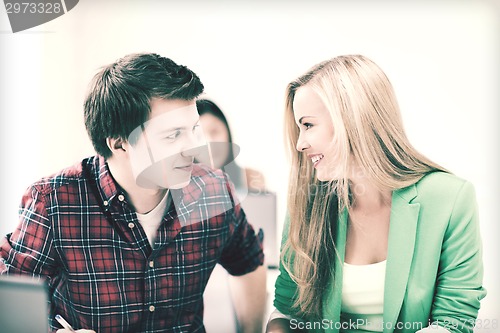 Image of smiling students looking at each other at school