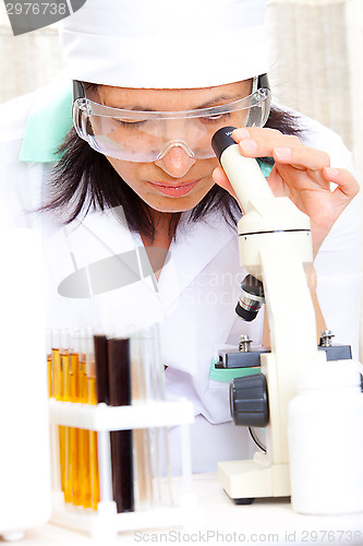 Image of scientist looking into microscope