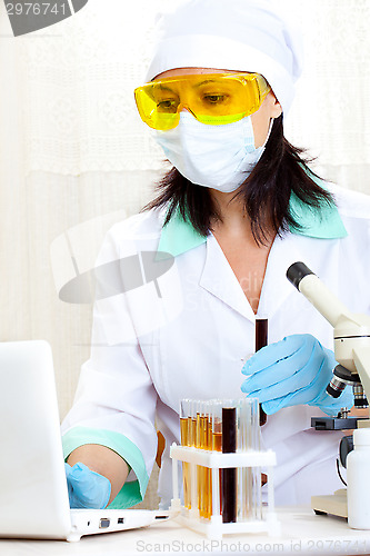 Image of doctor looking at a test tube of black solution