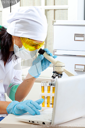 Image of scientist looking into microscope