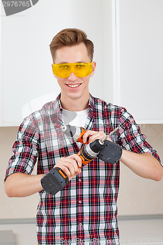 Image of Worker with electric drill and scredriver