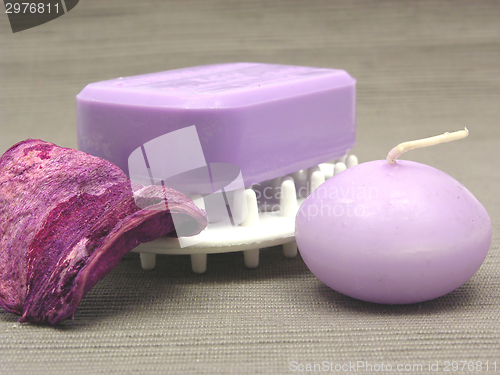 Image of Lilac soap with candle on a  gray background