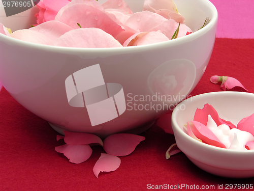 Image of Pink roses and cream in  white bowls of chinaware on red background