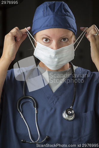 Image of Female Doctor or Nurse Putting on Protective Face Mask