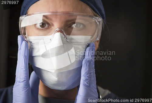 Image of Female Doctor or Nurse Putting on Protective Facial Wear