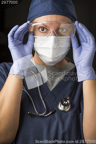 Image of Female Doctor or Nurse Putting on Protective Facial Wear