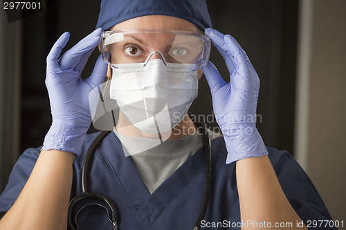 Image of Female Doctor or Nurse Putting on Protective Facial Wear