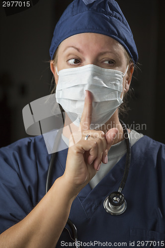 Image of Secretive Female Doctor with Finger in Front of Mouth
