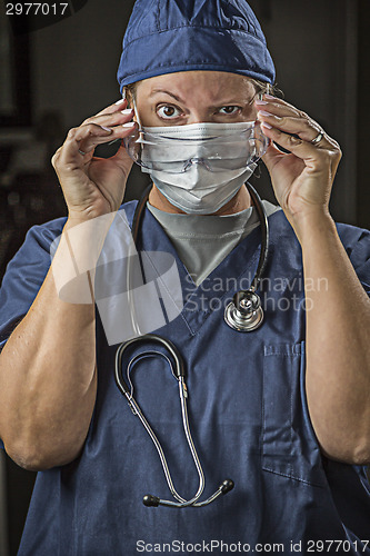 Image of Female Doctor or Nurse Putting on Protective Facial Wear