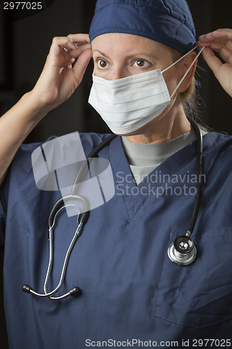 Image of Female Doctor or Nurse Putting on Protective Face Mask