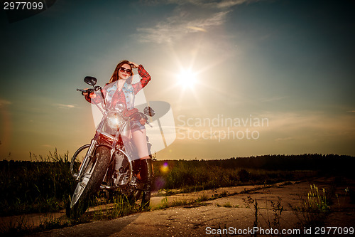 Image of Biker girl sitting on motorcycle