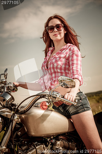 Image of Biker girl sitting on motorcycle