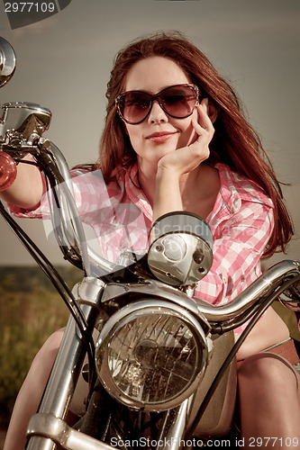 Image of Biker girl sitting on motorcycle