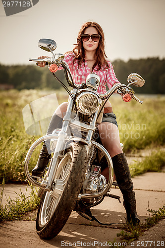 Image of Biker girl sitting on motorcycle