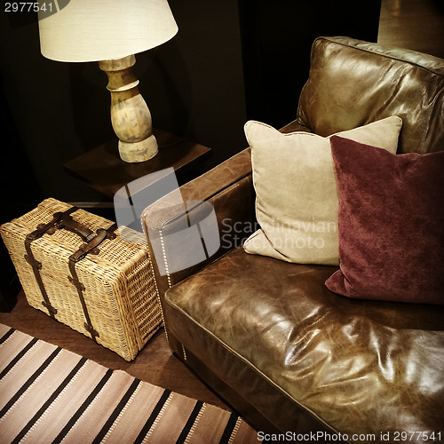 Image of Leather sofa, lamp and rattan suitcase