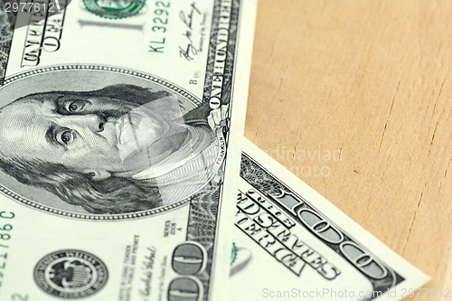 Image of Close-up of a 100 dollars banknotes on wooden background