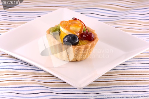 Image of Chocolate cake with cherry and olive on white plate