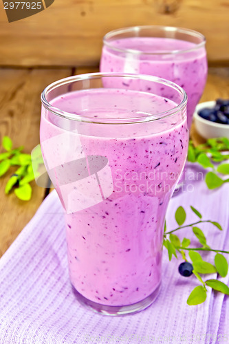 Image of Milkshake with blueberries in glasses on board
