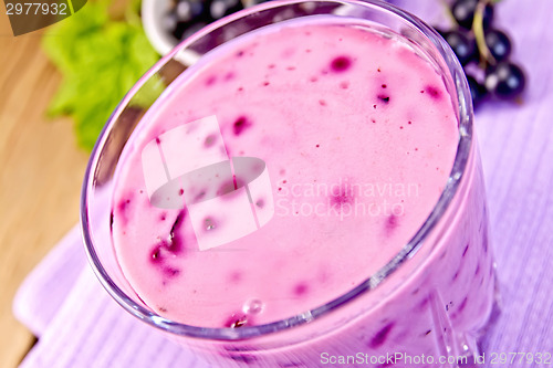 Image of Milkshake with black currants in glass on board