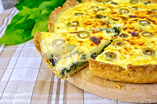 Image of Pie with spinach and olives on fabric