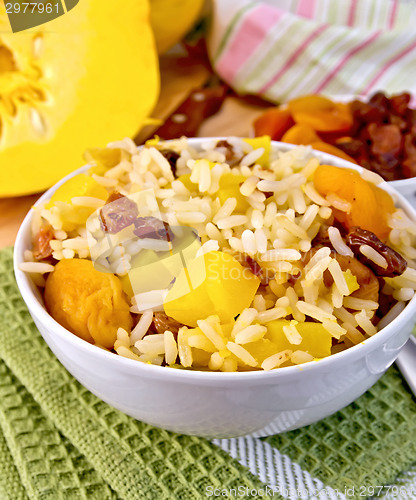Image of Pilaf fruit with pumpkin in bowl on board