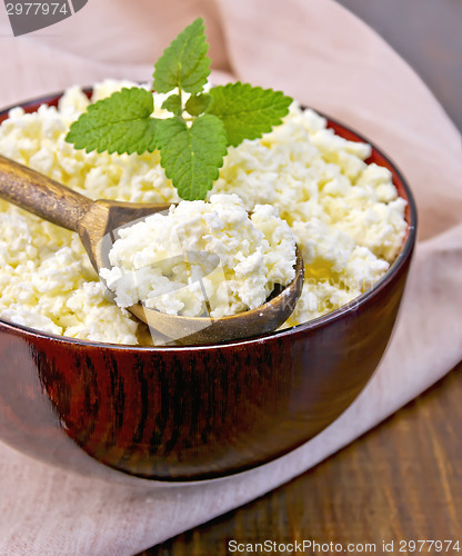 Image of Curd in wooden bowl with spoon on board