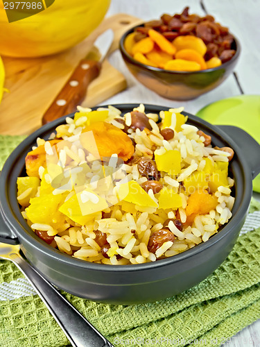 Image of Pilaf fruit with pumpkin in pan on board