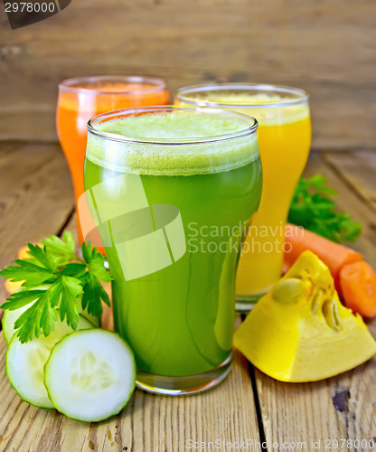 Image of Juice vegetable in three glasses with vegetables on board