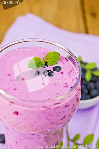 Image of Milkshake with blueberries in glass on board