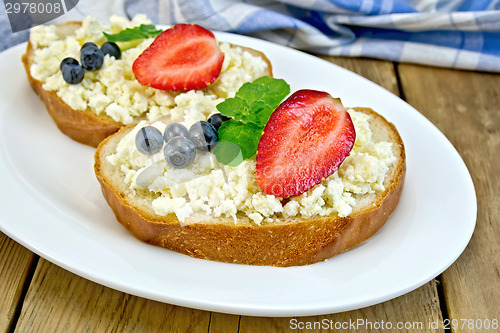 Image of Bread with curd and berries in plate on board