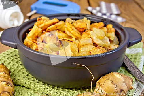 Image of Jerusalem artichokes roasted in pan with meter on board