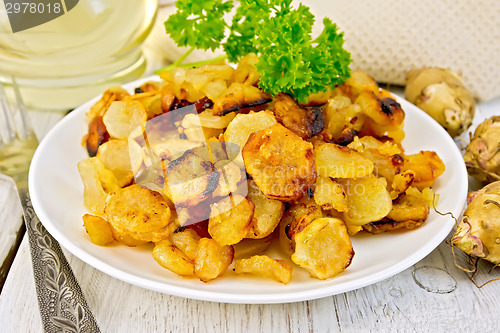 Image of Jerusalem artichokes fried in plate on light board