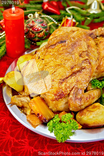 Image of Chicken Christmas with toys and candles on tablecloth