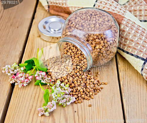 Image of Buckwheat in glass jar on board with flower
