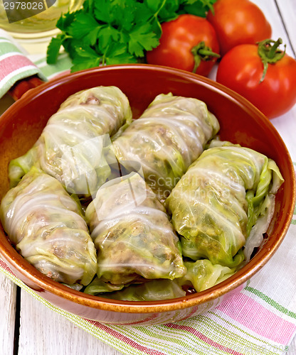 Image of Cabbage stuffed with sauerkraut in ceramic pan on napkin