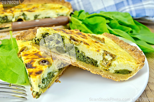 Image of Pie with spinach and cheese in plate on board