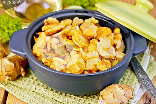 Image of Jerusalem artichokes roasted in pan on board