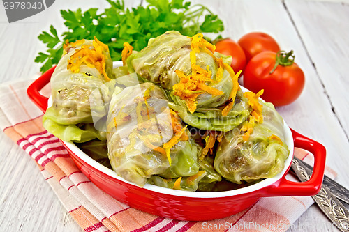 Image of Cabbage stuffed and carrots in pan on napkin