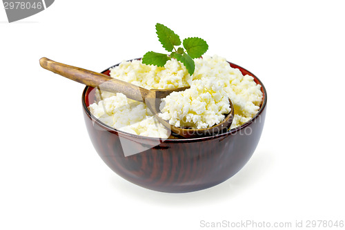 Image of Curd in wooden bowl with spoon and mint