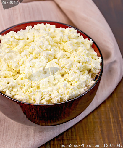 Image of Curd in wooden bowl with napkin on board