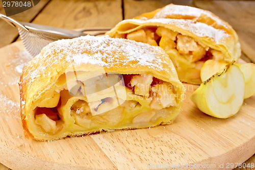 Image of Strudel with apples and strainer on board