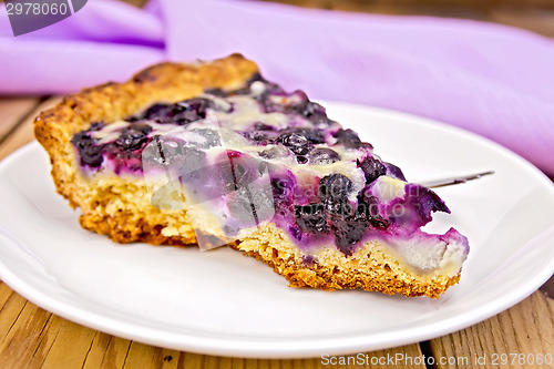 Image of Pie with blueberries and spoon in plate on board