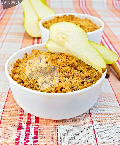 Image of Crumble with pears in bowl on linen tablecloth