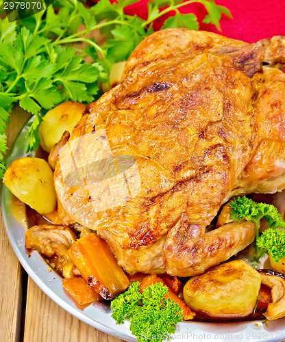 Image of Chicken baked with vegetables in dish on board