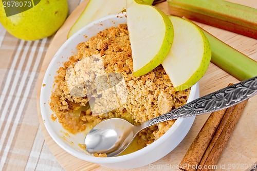 Image of Crumble with pears and rhubarb in bowl on linen tablecloth