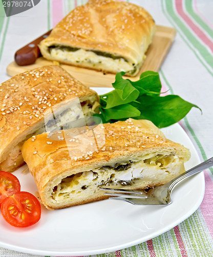 Image of Roll filled with spinach and cheese on tablecloth