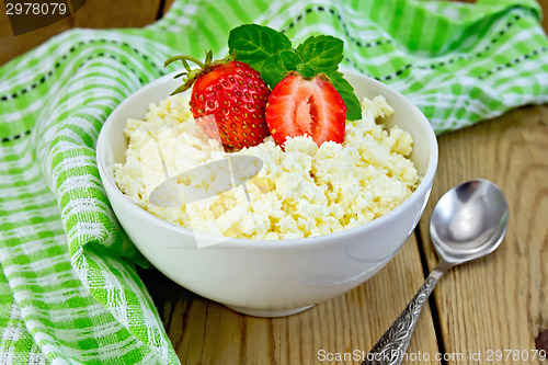 Image of Curd with strawberries in bowl on board