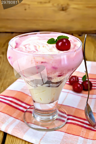 Image of Dessert milk with cherry on napkin and board